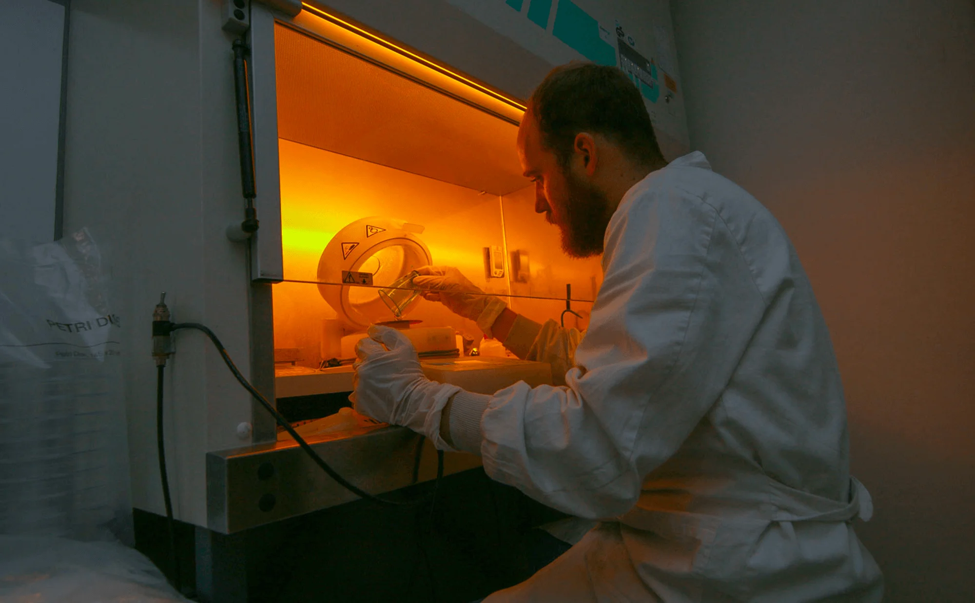 Benjamin Sévénié, PhD travaillant sous la hotte du laboratoire avec le spin coater, fabriquant un moule SU-8 à Blackhole Lab. | Crédit photo : Julien Ridouard